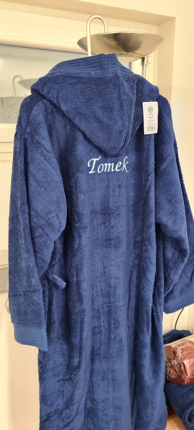 Dunkelblauer Bademantel mit dem gestickten Namen Tomek