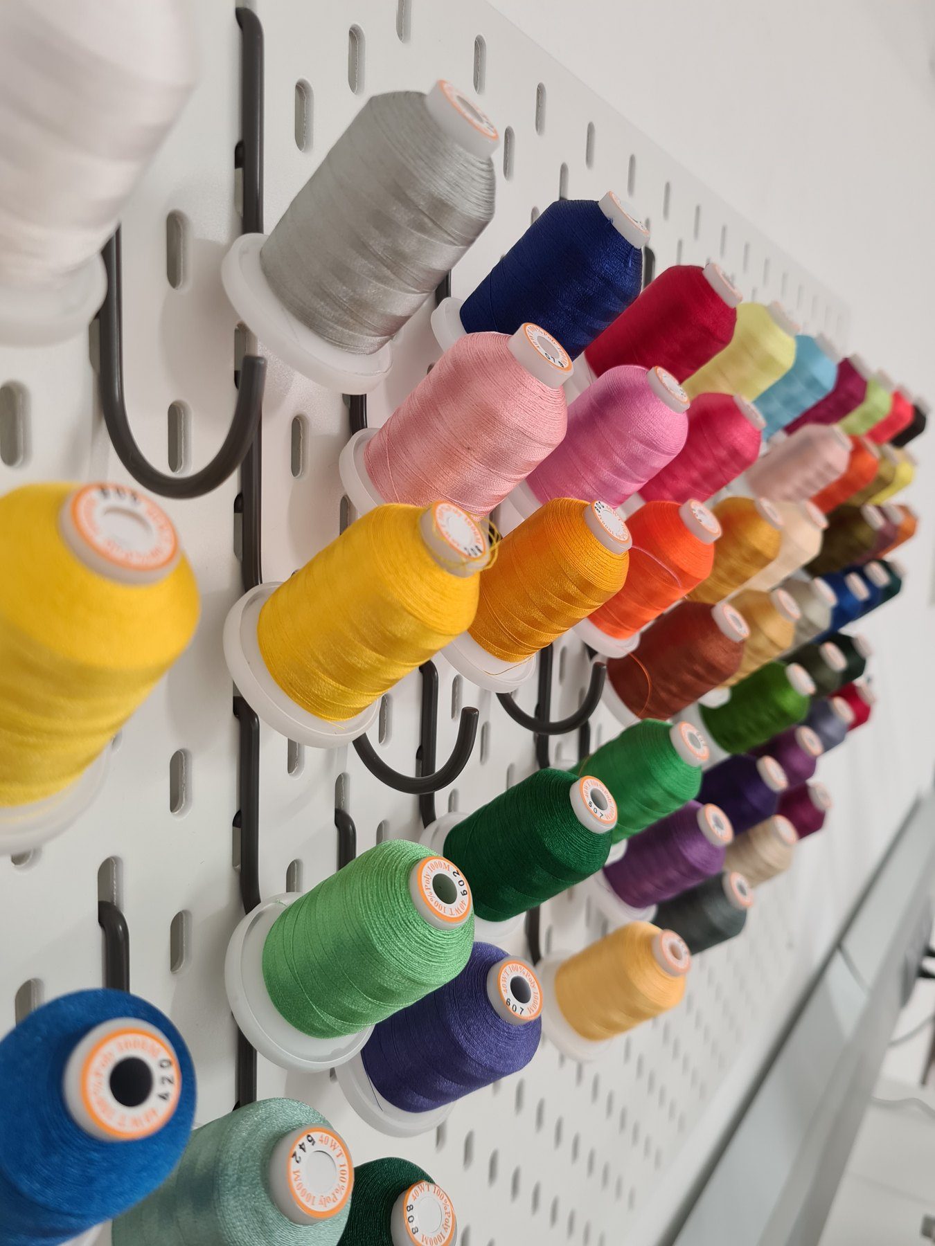 Wand mit vielen bunten Garnrollen in der Werkstatt