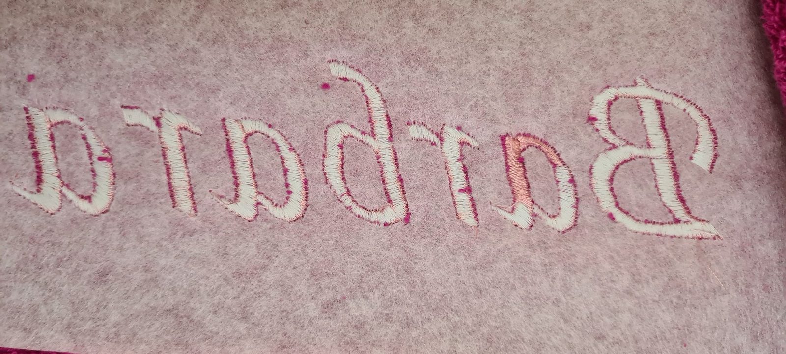 Nahaufnahme von rosa Frottee mit dem gestickten Namen Barbara